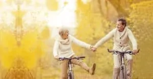 Older couple laughing while riding bicycles together